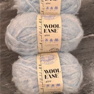 Three skeins of Lion Brand Wool Ease aire yarn
